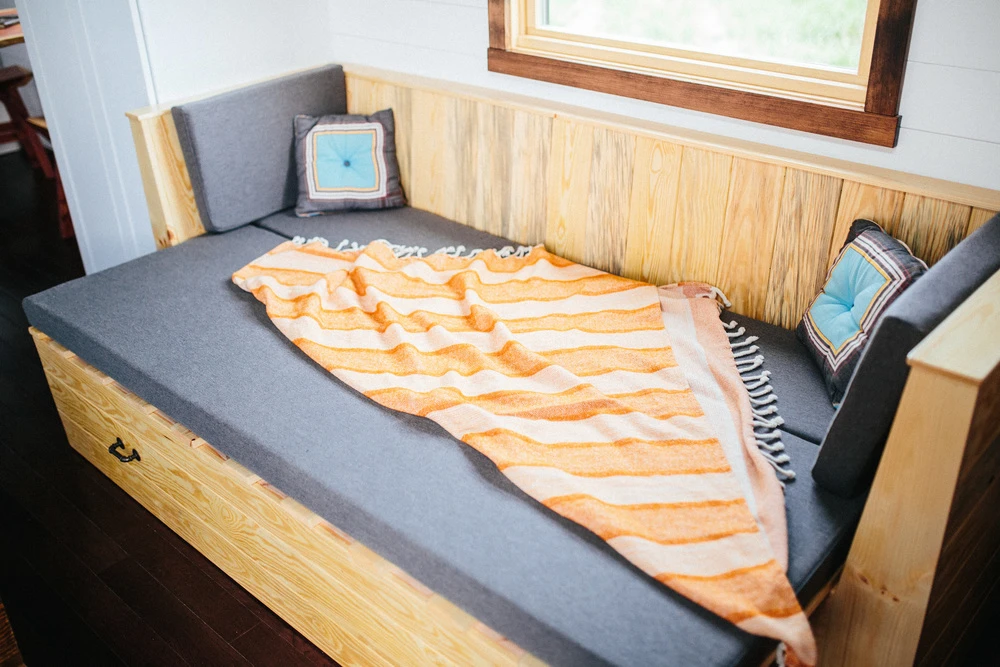 The couch has integrated storage space and pulls out to serve as a guest bed