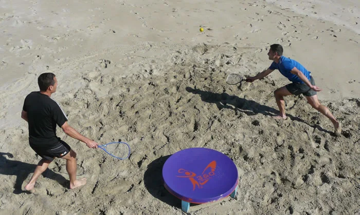 In the new racquet game of 360ball, players hit a ball into a central concave dish, trying to rebound it out of the reach of their opponents