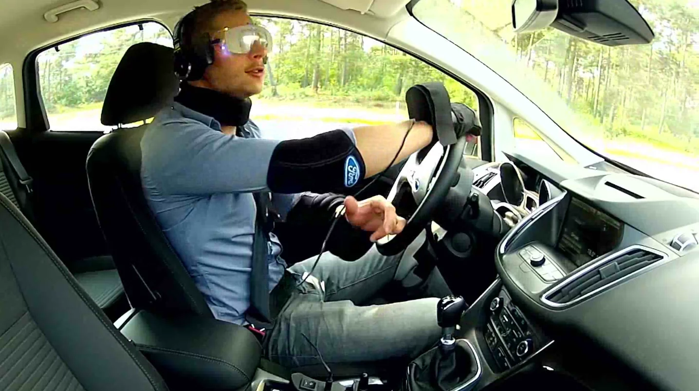 The suit uses strategically-placed weights and heavy padding reduce mobility in the arms and legs, while goggles and headphones reduce awareness