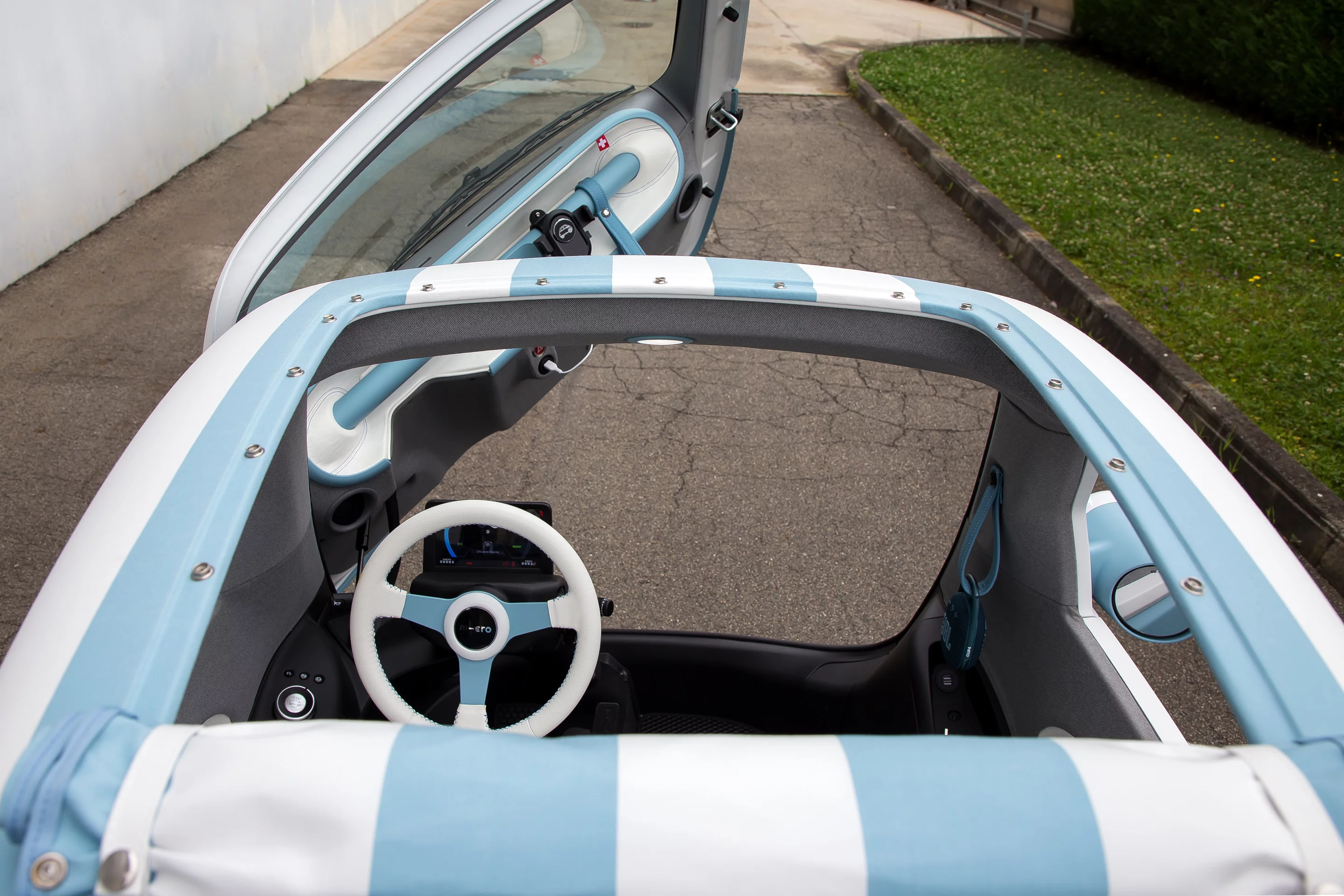 The adorable Microlino Spiaggina electric micro car's fabric sunroof can be rolled back to enjoy the breeze on a warm day