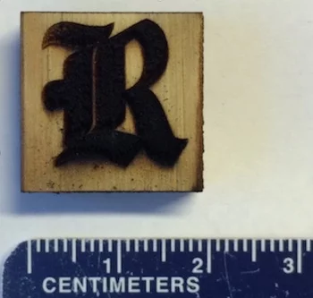 The Rice University athletics logo, made out of laser-induced graphene on a piece of pine