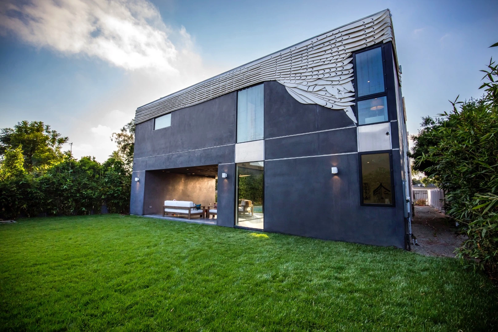 The unusual home is partially wrapped in over 300 pieces of white powder coated aluminum