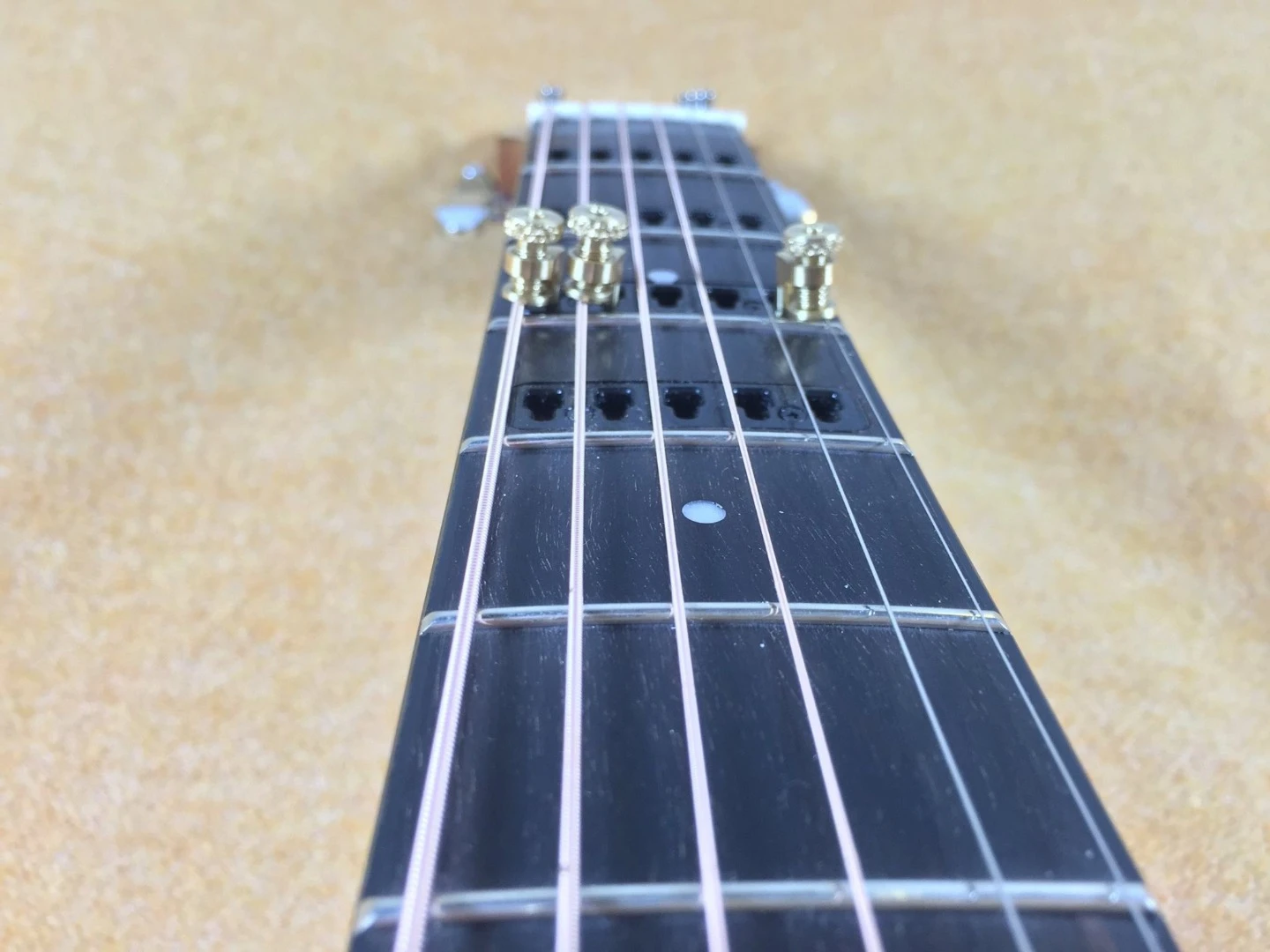 Metal capos are locked in position on individual strings of the Gillis Capo Guitar
