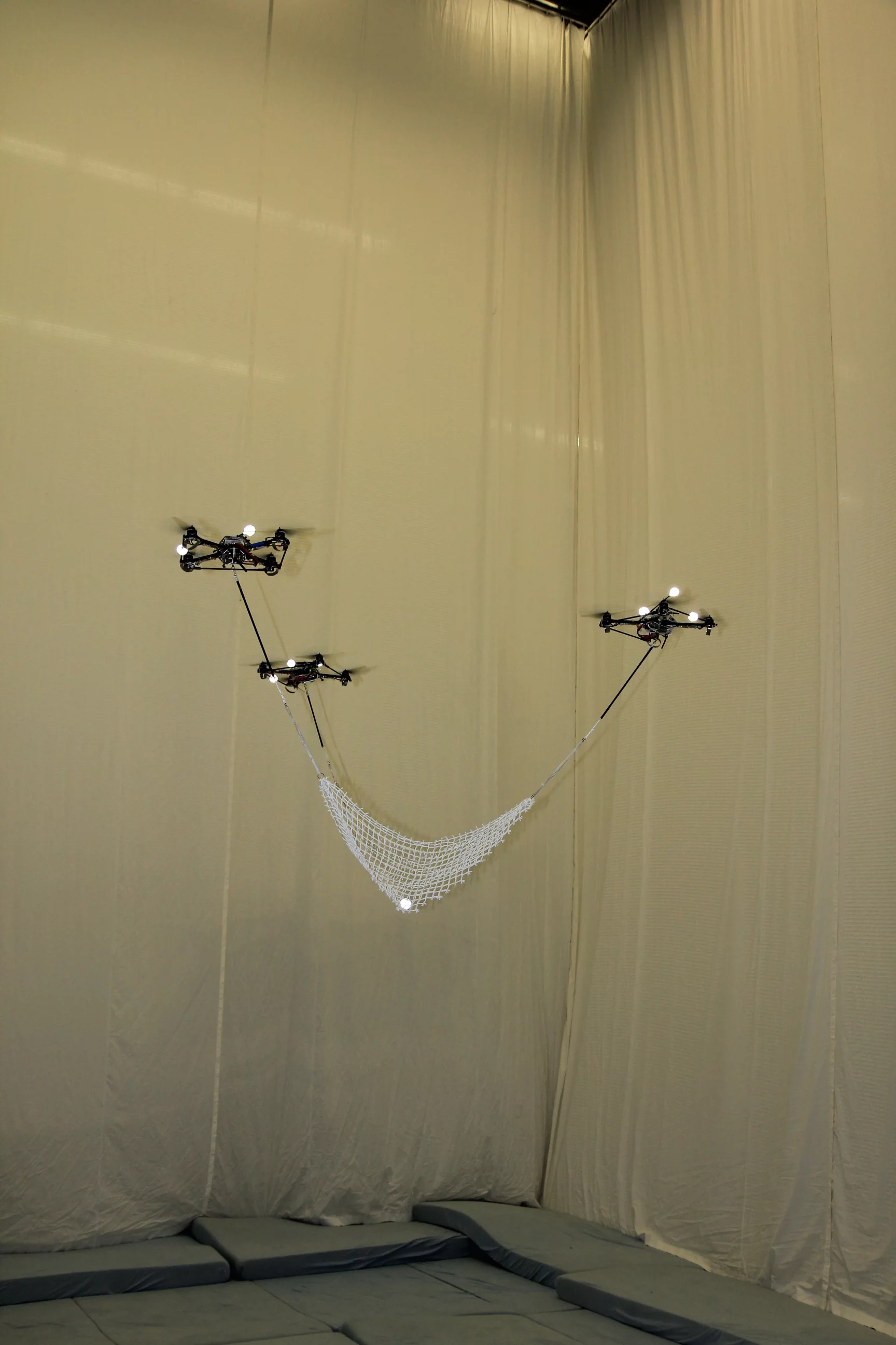 Flying quadrocopters at ETH Zurich's Flying Machine Arena catch and launch a ball using a net spread between them