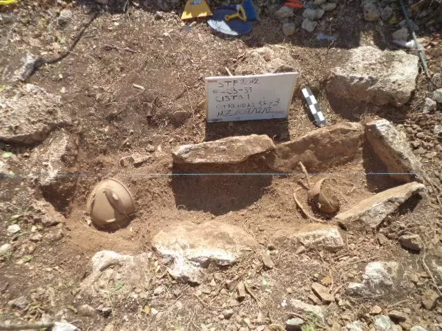Maya burial with typical ceramic offerings, a plate covering the head of the deceased individual and cup placed likely with food