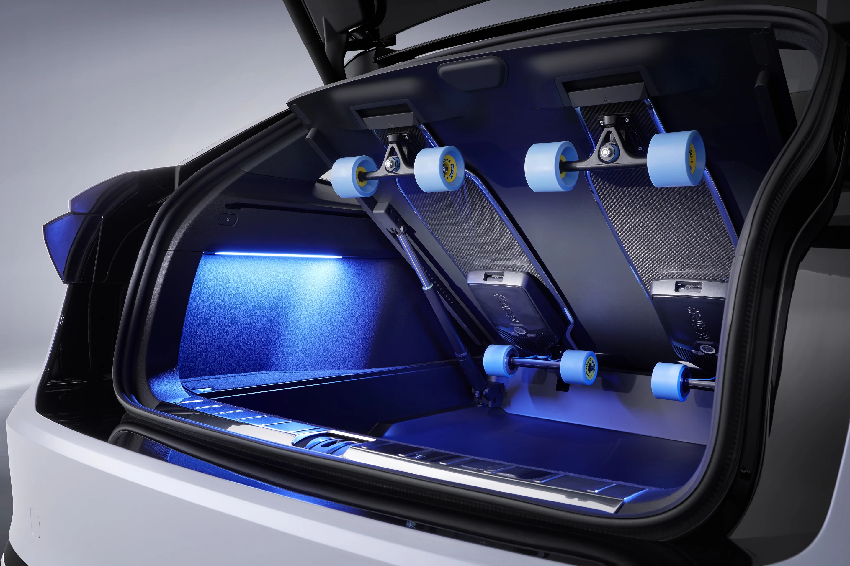 Two electric, longboard-style skateboards hide under the rear cargo area's floor for last-mile runs