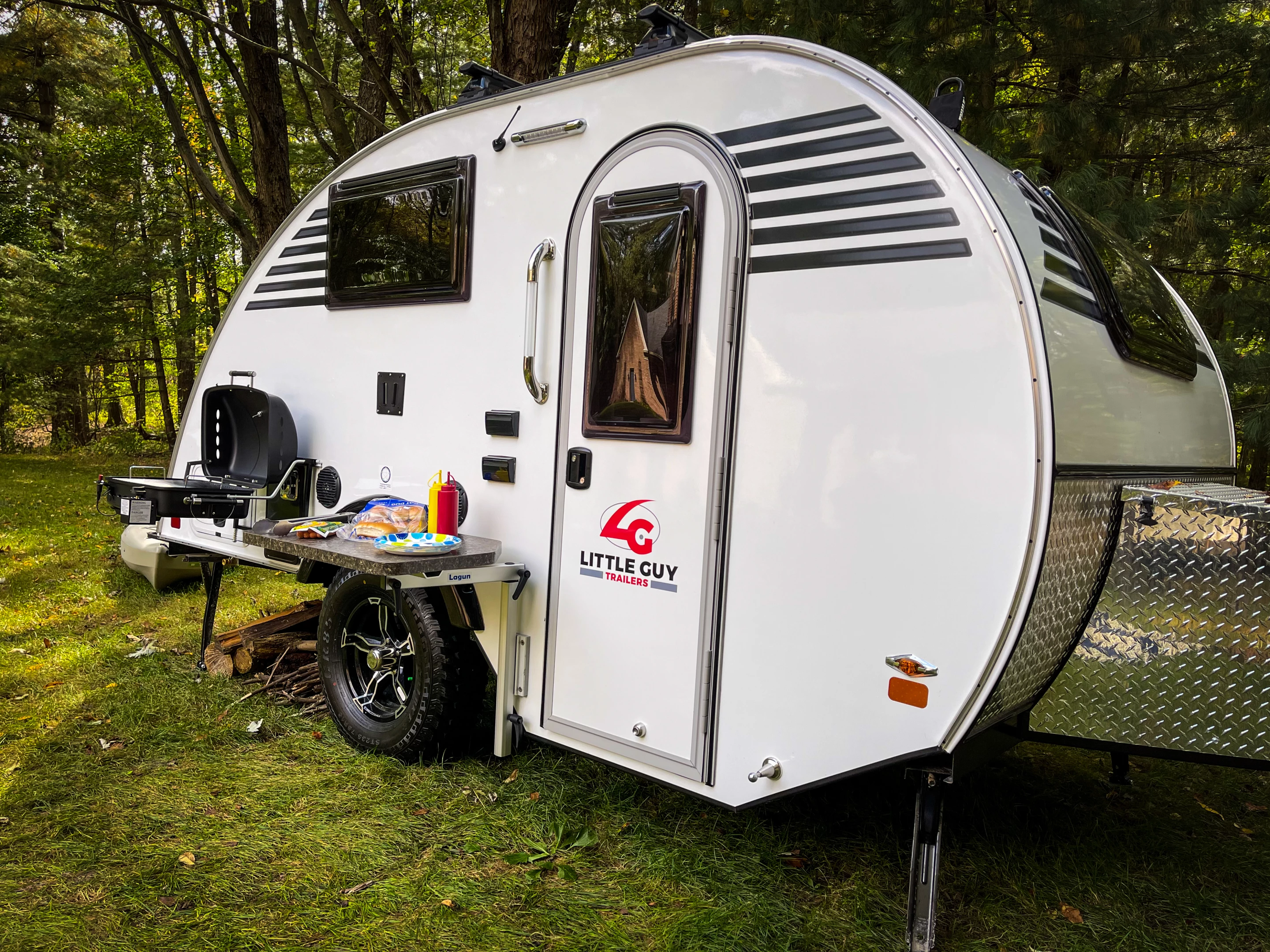 The all-new Little Guy Micro Max teardrop trailer comes with exterior attachments for a Lagun table and BBQ grill, creating an outdoor kitchen