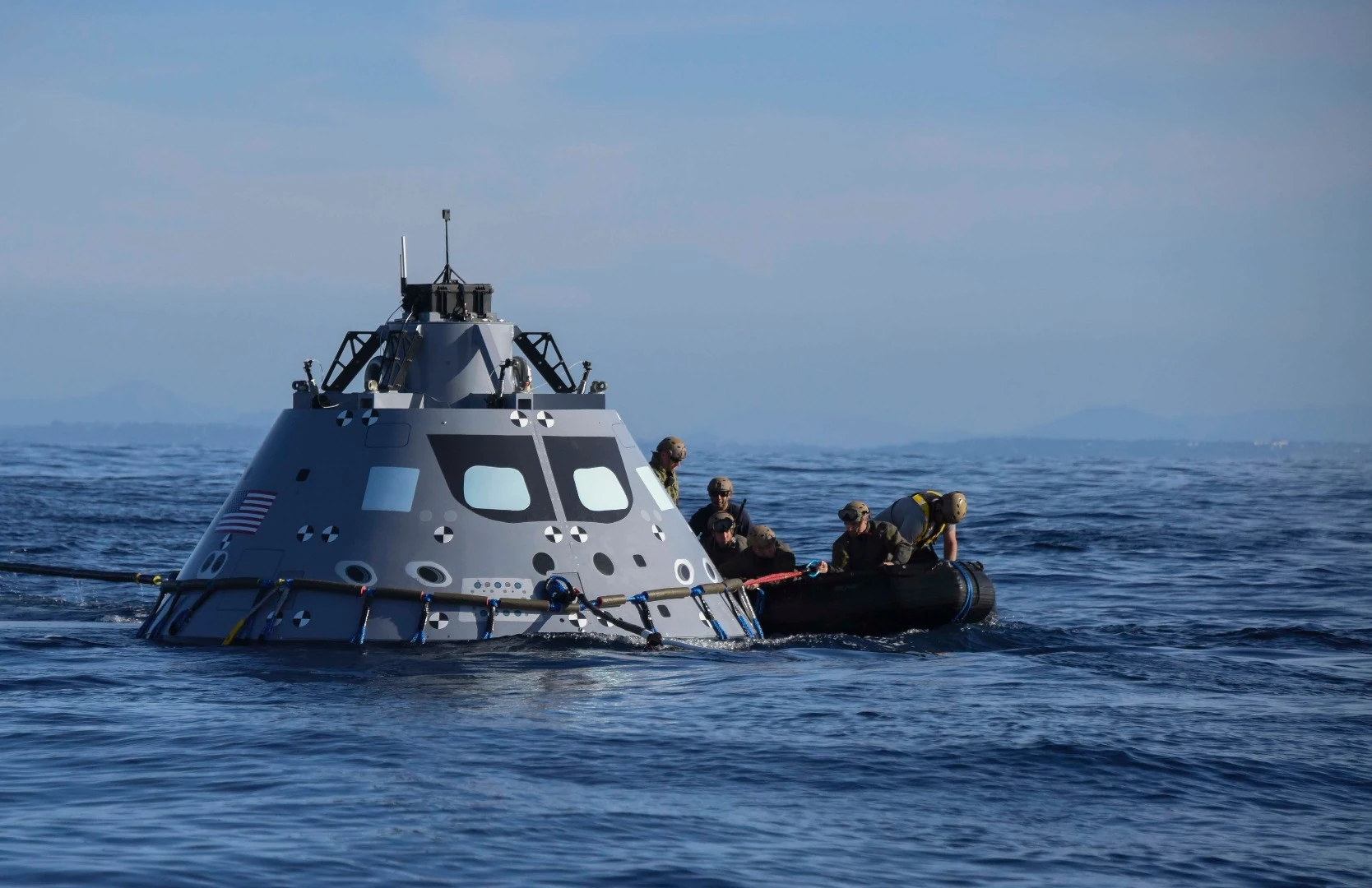 Navy divers from Explosive Ordnance Disposal Mobile Unit (EODMU) 3 attach an inflatable ring to NASA's Orion test vehicle