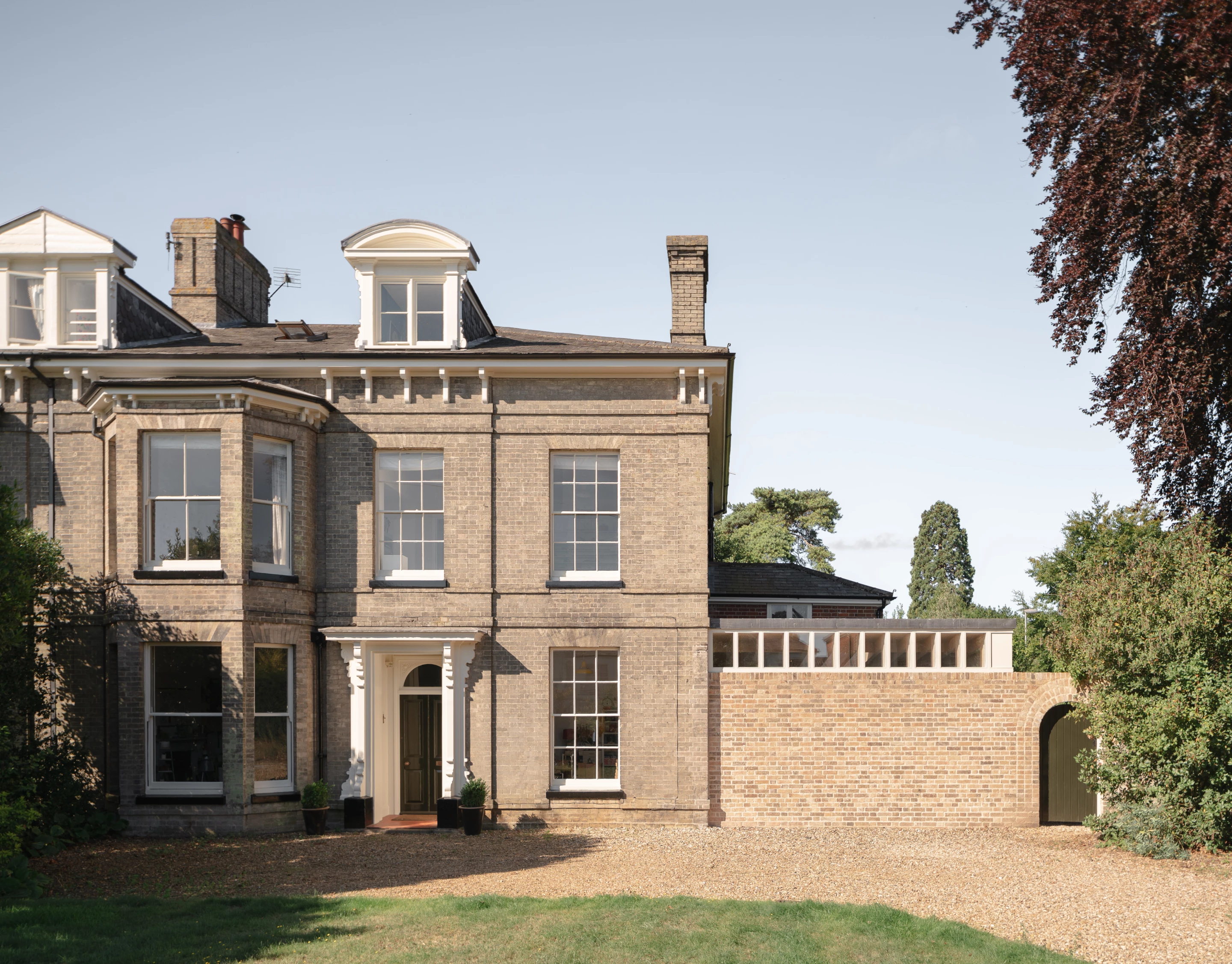 The Garden Studio was designed by Brisco Loran and James Alder Architect and is located in Norfolk. It creates a simple single-storey extension that replaces a garage on the side of a beautiful Victorian house