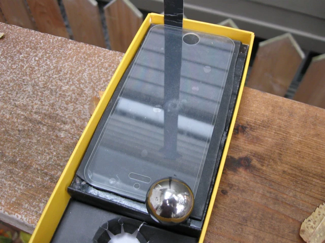 A Rhino Shield-protected piece of Gorilla Glass 2, with a sheet of rubber underneath, post ball-drop