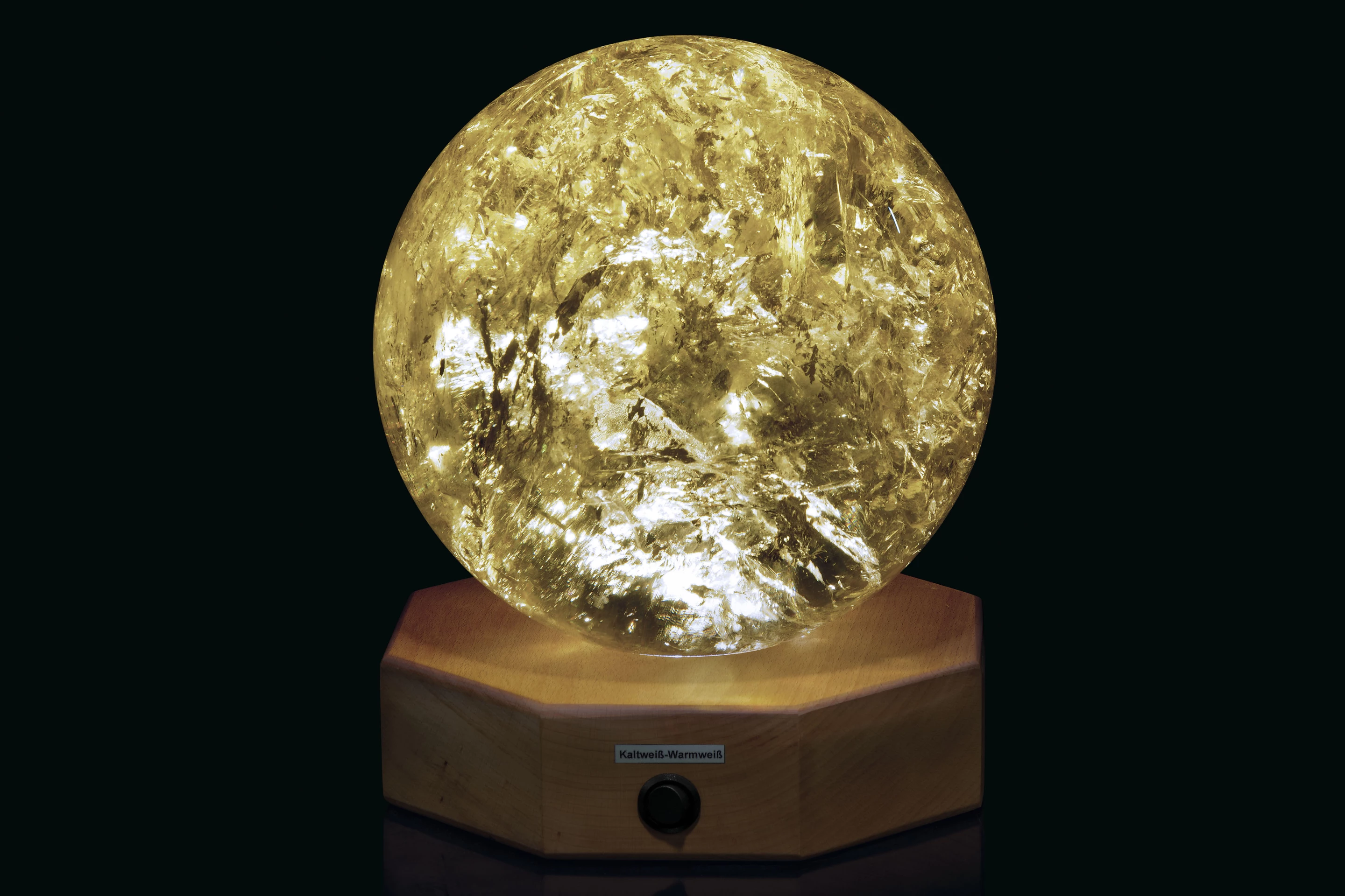 This 81⁄2 inch (21.5 cm) diameter spherical Citrine sample from Brazil has been polished to reveal areas of rainbow iridescence. The specimen is mounted on a wood base with lighting for the specimen from below.