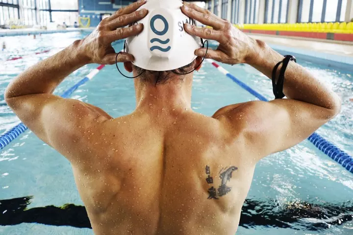 The SwimBot is mounted beneath the user's swim cap