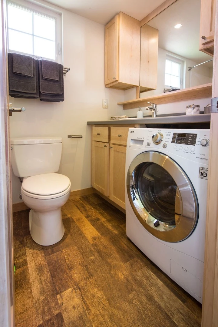 The bathroom includes a toilet, shower/tub, storage, and space for a washer/dryer