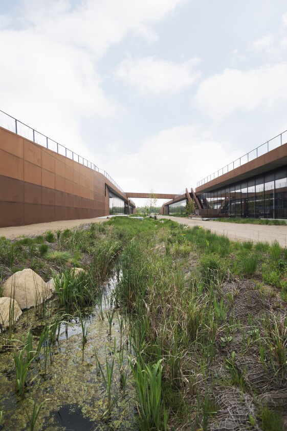 The Solrødgård Water Treatment Plant includes a small creek that shows water being purified naturally with foliage, contrasting with the industrial process being used inside