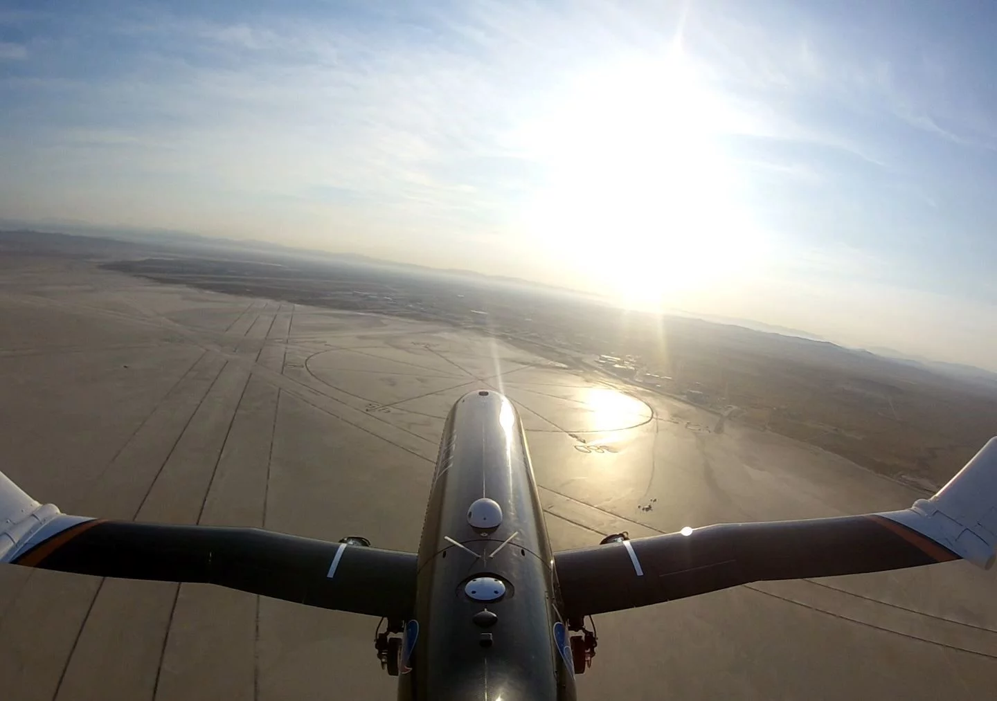 The subscale testbed PTERA flies over NASA Armstrong Flight Research Center in California with the outer portions of its wings folded 70 degrees upwards