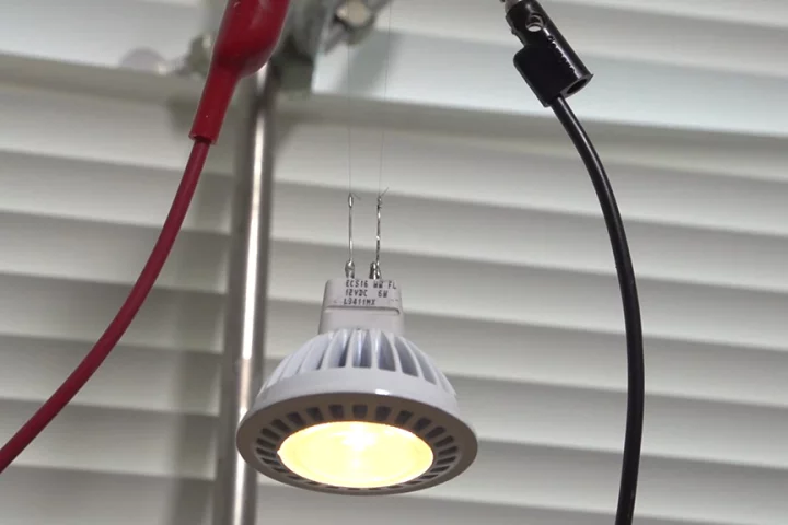 Two strands of the new CNT fiber support and supply current to an LED bulb