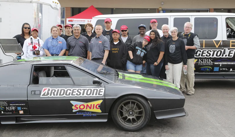 The MINDDRIVE team pose for a group photograph with the electric Lotus Esprit
