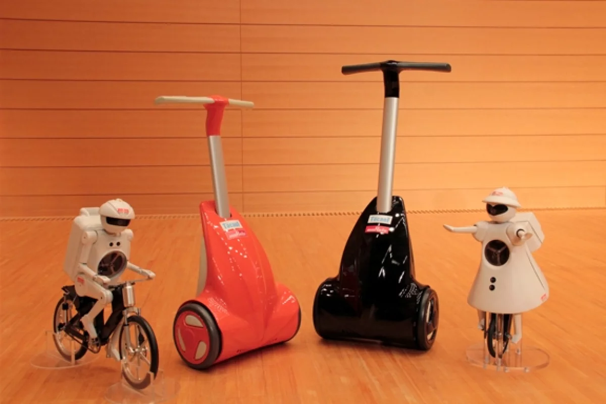Murata Manufacturing's KeePace, a walk-assist device for the elderly or disabled, stands next to the company's mascot robots.