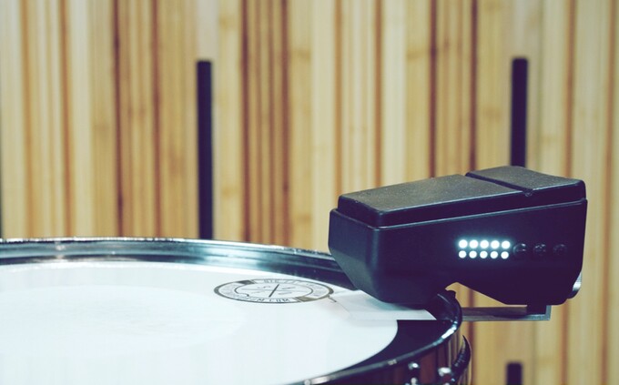 An L-bracket attachment currently mounts to the tension rod of a drum, such as a snare or tom, and the DrēmTrigger is attached to that with a thumbscrew