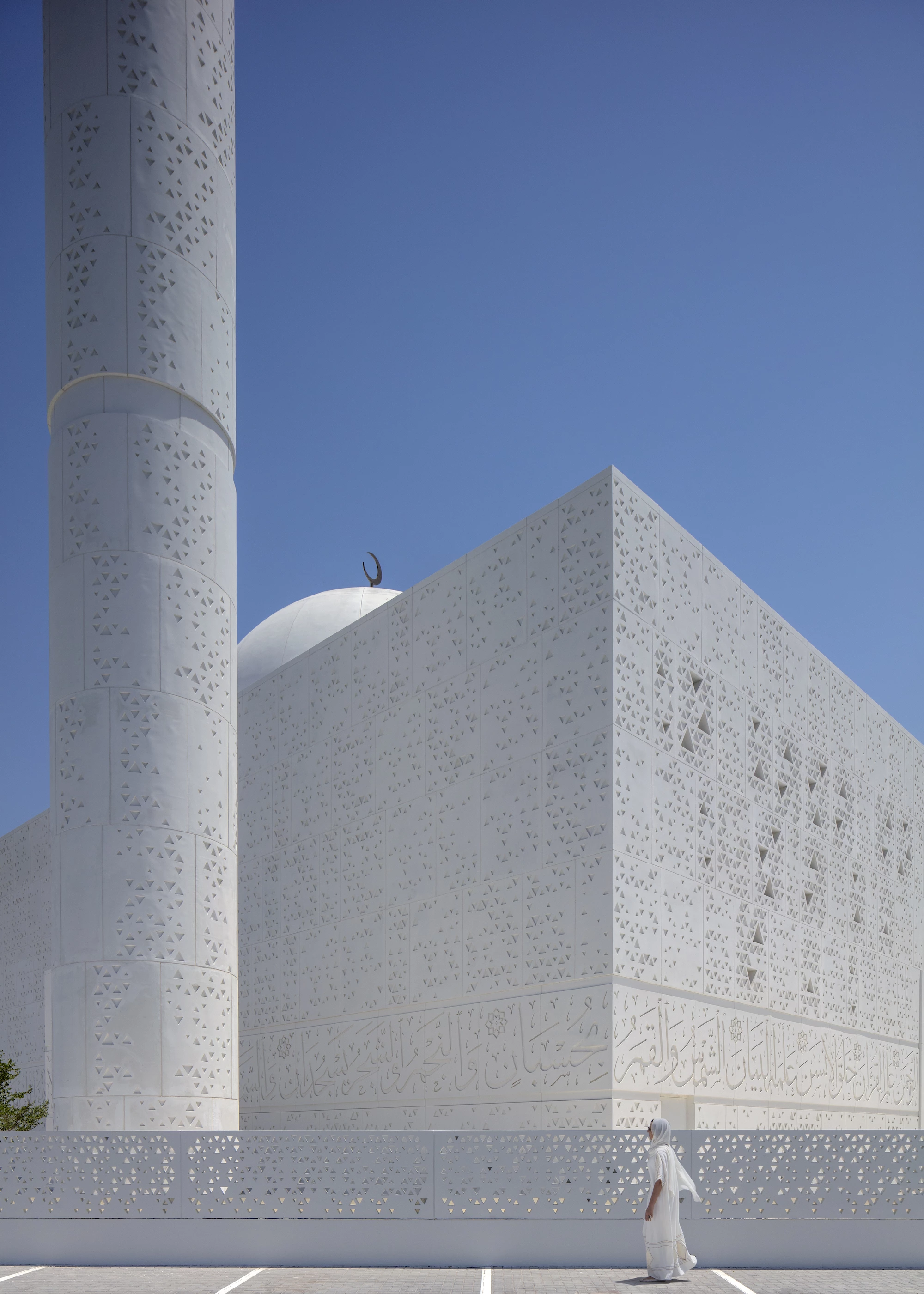 The Mosque of Light was designed by Dabbagh Architects and is located in the UAE. The project is finished in white stone that is enlivened by geographic forms and calligraphy