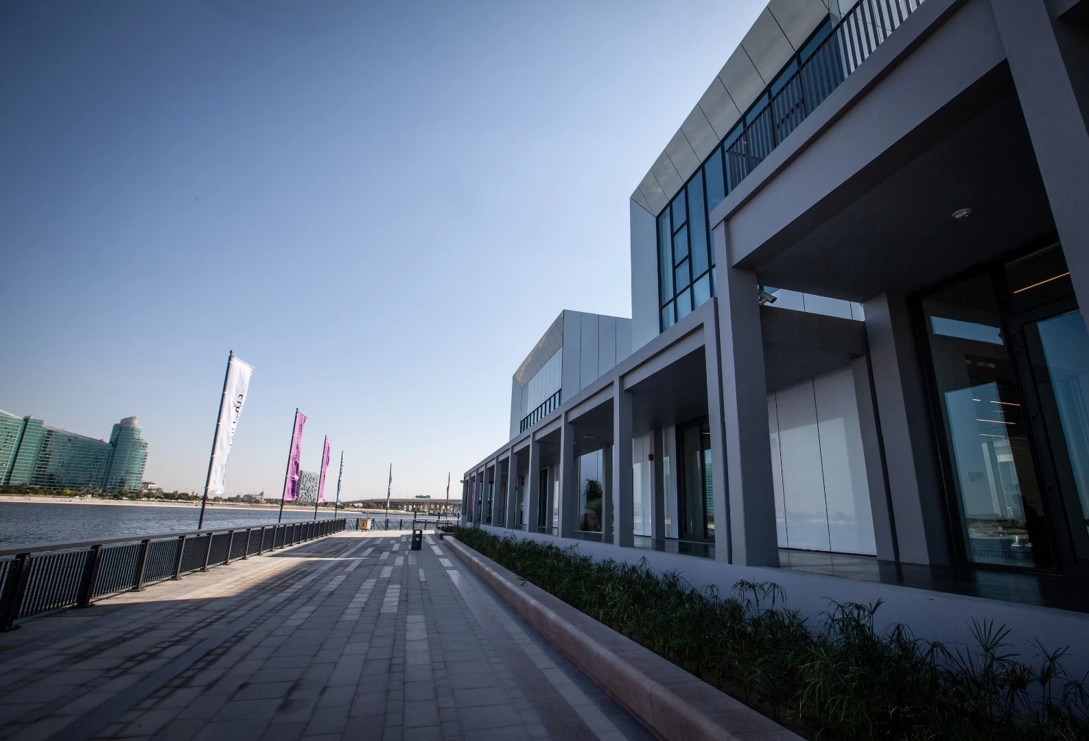 A wooden promenade runs alongside the edge of the Dubai Creek outside the Jameel Arts Centre