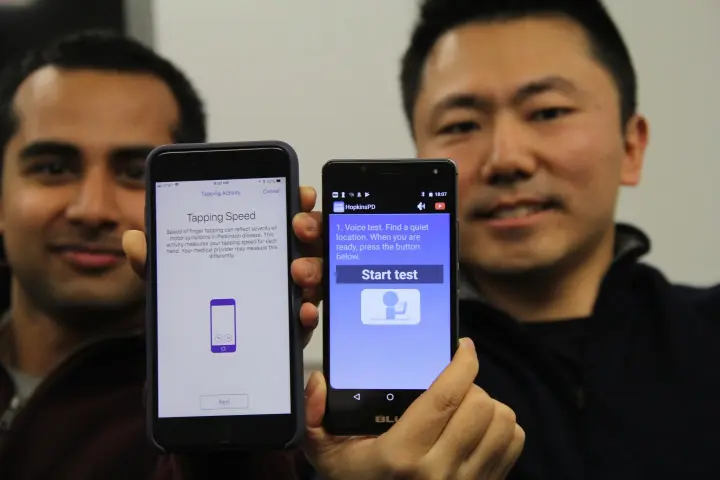 Johns Hopkins computer science students Srihari Mohan (left) and Andong Zahn display the iOS and Android versions of the app they helped design