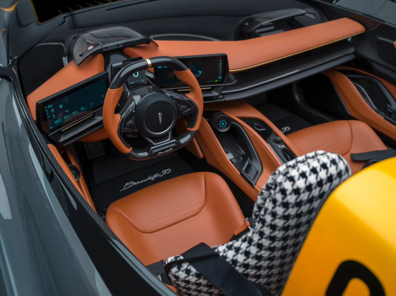 The digitized cockpit wears a combination of tan leather, houndstooth fabric and carbon fiber