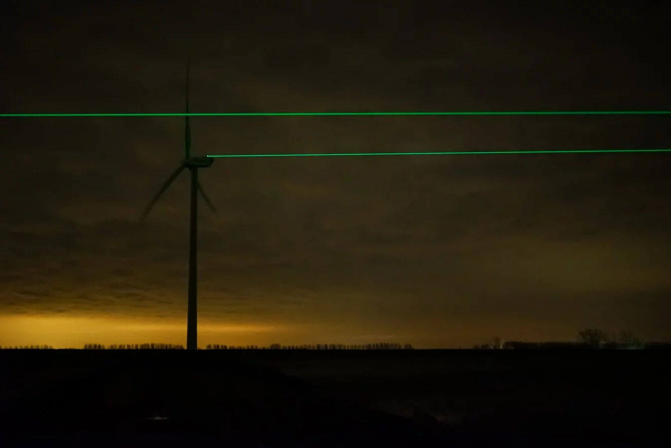 Aiming and stabilization systems are used to shine an LED beam from the blade of one turbine to the blade of another