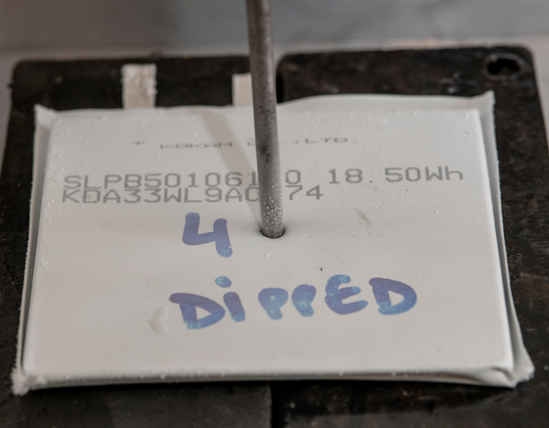 A nail is driven through one of the frozen lithium-ion cells, without incident – doing so at room temperature caused the cell to ignite