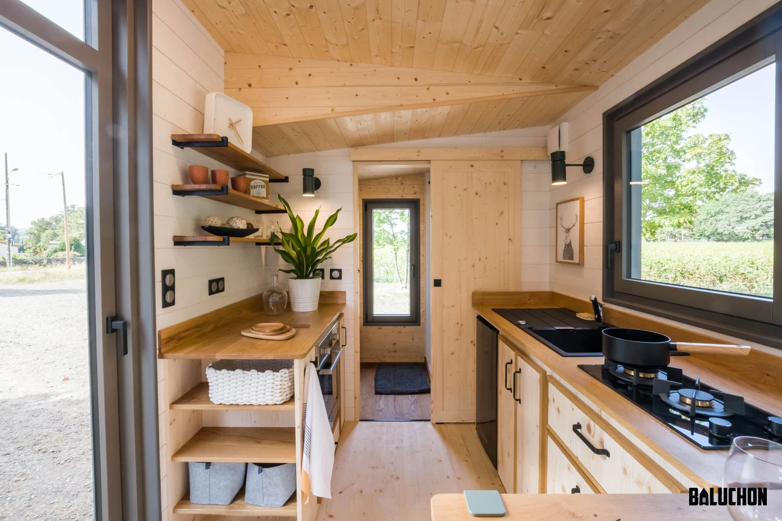 The Eucalyptus' kitchen includes an oven, a separate propane-powered two-burner stove, sink, a small fridge and custom cabinetry