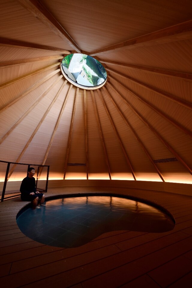 The wooden interior of the bath at the Kiyotsu Gorge Tunnel slopes upwards like a volcano to an opening at the top