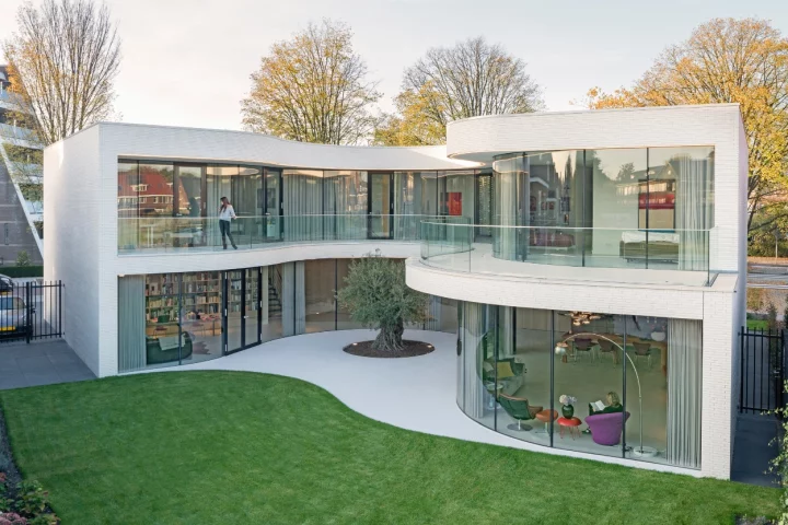 Casa Kwantes' expansive glazed facade curves around an olive tree