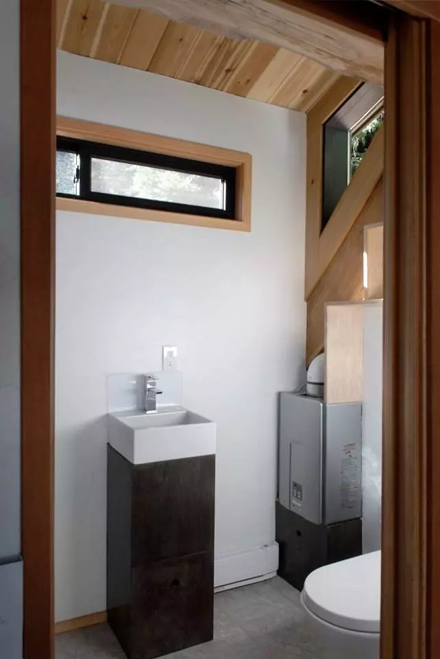 The bathroom includes low flush toilet, shower with dual shower heads, sink, storage, and ceiling fan