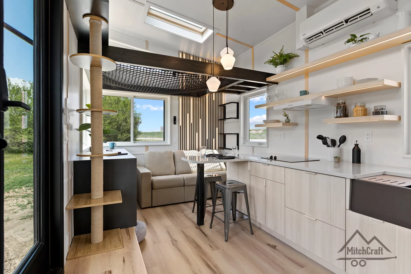The living room in Casey's 32' x 10' Tiny Home is topped by a netted loft area