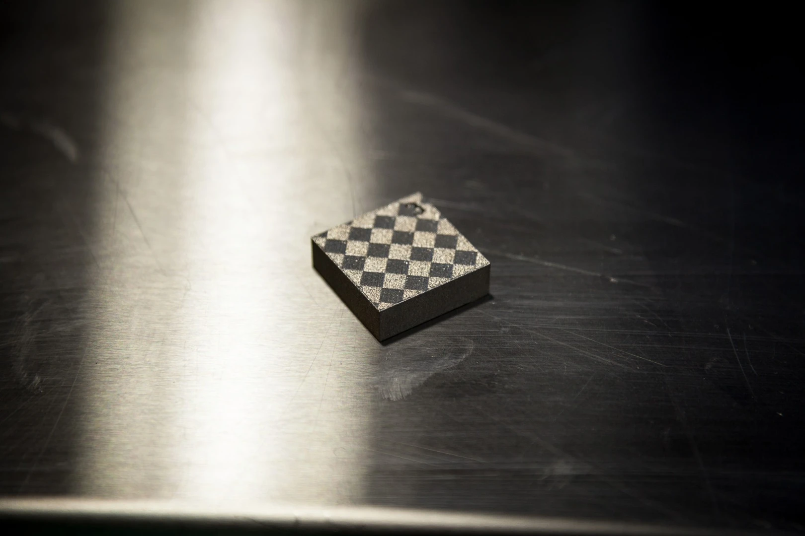 Demo print from the Concept Laser machine, showing the cross-hatched pattern typical of laser-melted titanium