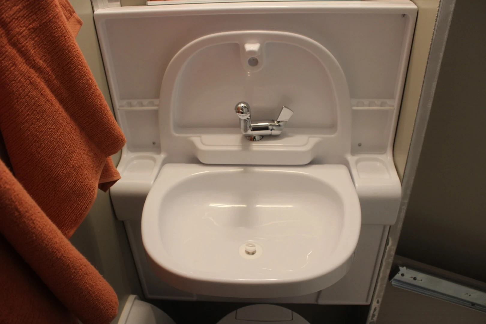 The SylvanSport bathroom features a foldaway sink and a shower that's cleared for use by the pull-out outdoor kitchen