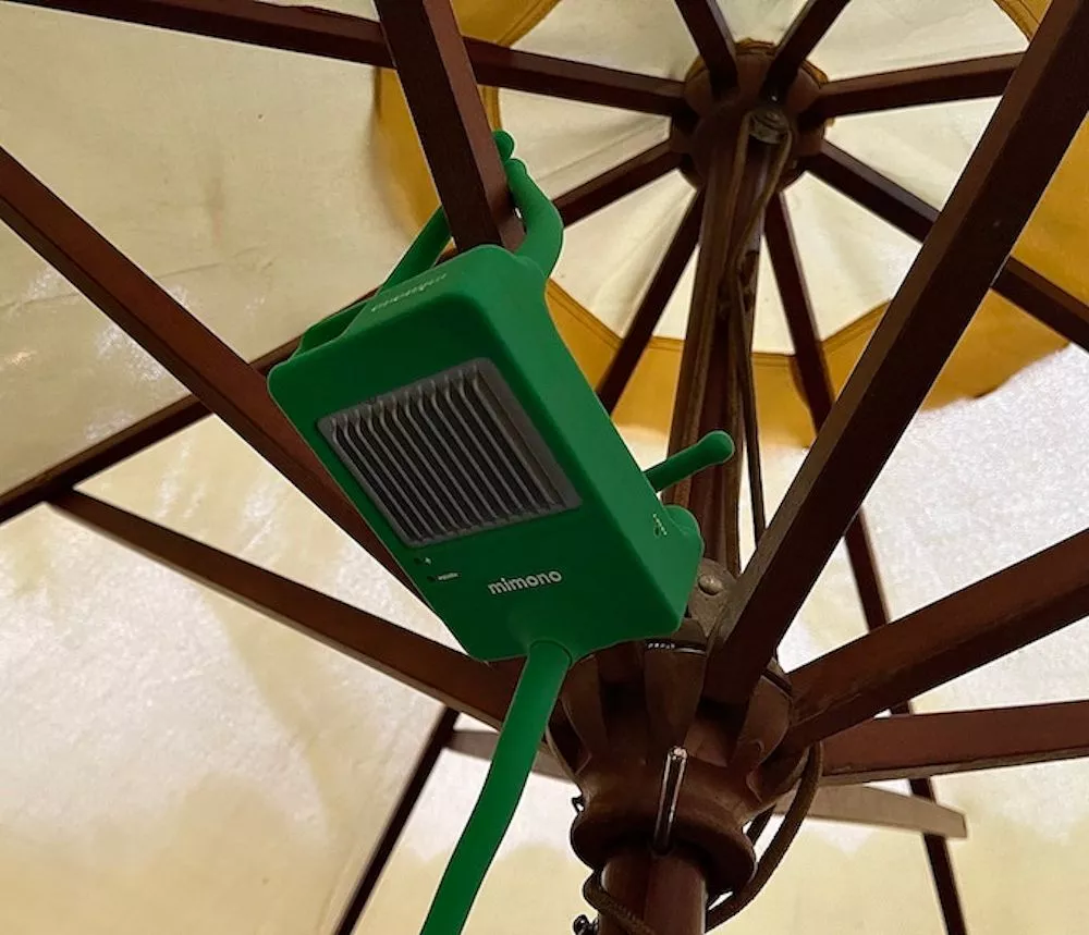 The projector's bendable legs allow for easy positioning on uneven surfaces, or hanging from a parasol frame