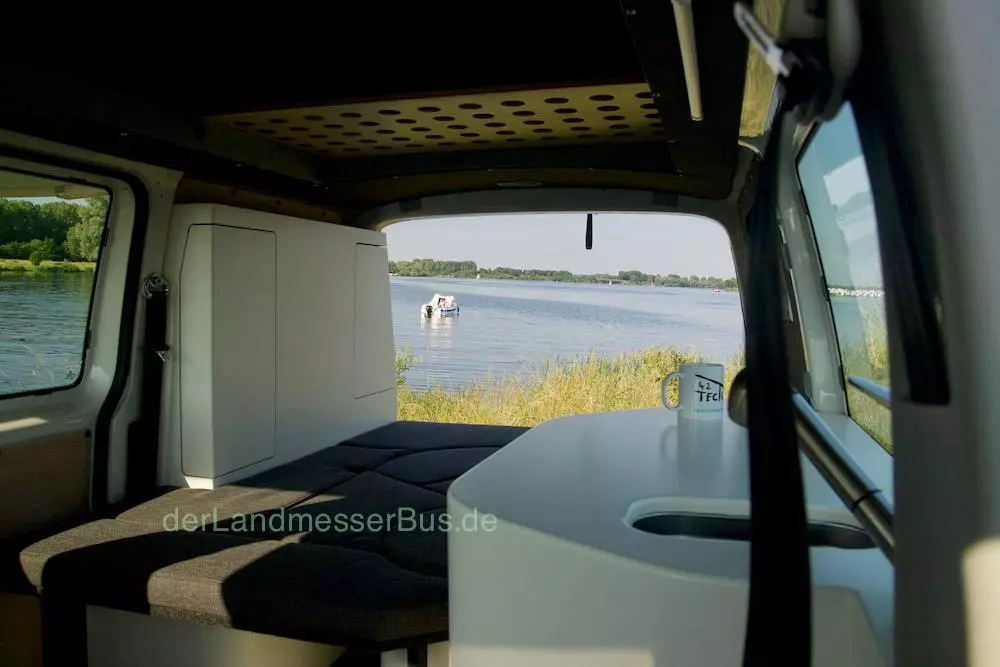 Despite its curvy design, the dinette inside Landmesserbus's VW Transporter camper does indeed compact into a bed