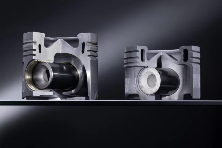 An aluminum piston (left) and one of the new steel pistons (right)