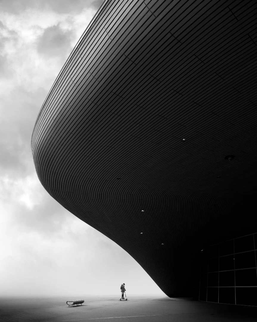 A scooter rider providing scale and context in relation to the Aquatics Centre, London