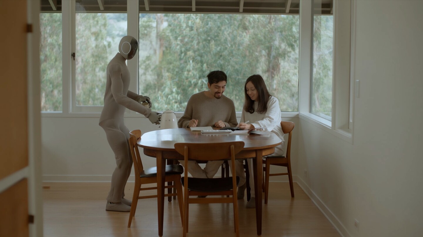 Neo Gamma politely offers the happy couple some coffee while they ignore its efforts
