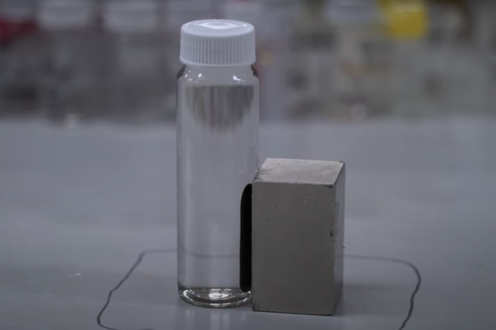 A sample of contaminated water being treated using the new technique, with the PFAS chemicals being attracted to the side with the magnet