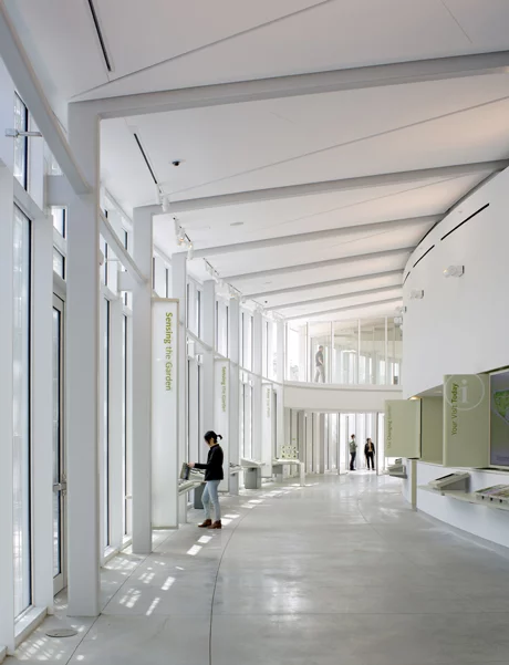 Dramatic floor-to-ceiling curved glass walls open out into the surrounding parkland and themed gardens