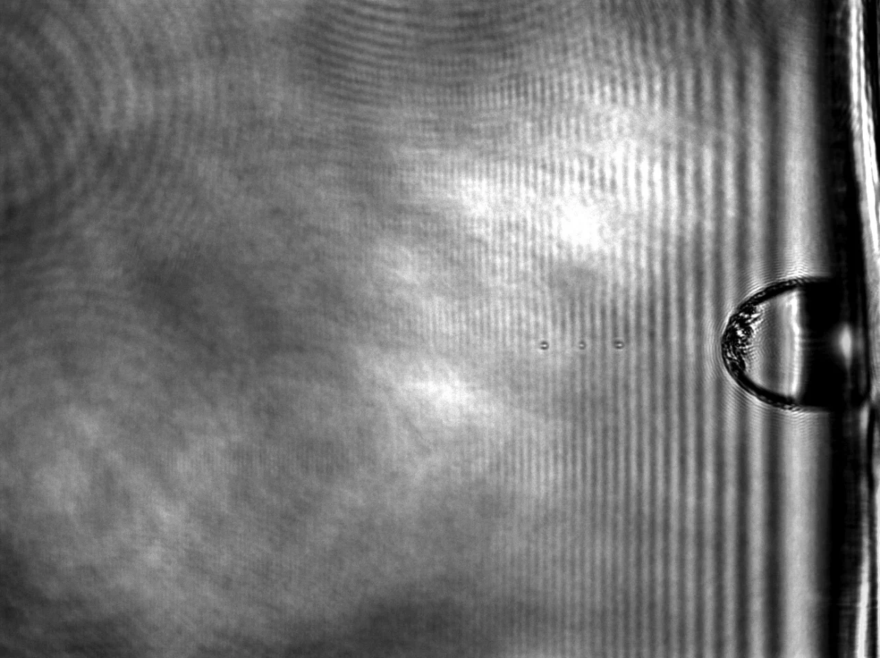 A microbullet traveling at supersonic speed is captured in this composite of three timed images, as it makes its way toward a suspended sheet of multilayer graphene (Image: Thomas Research Group/Rice University)