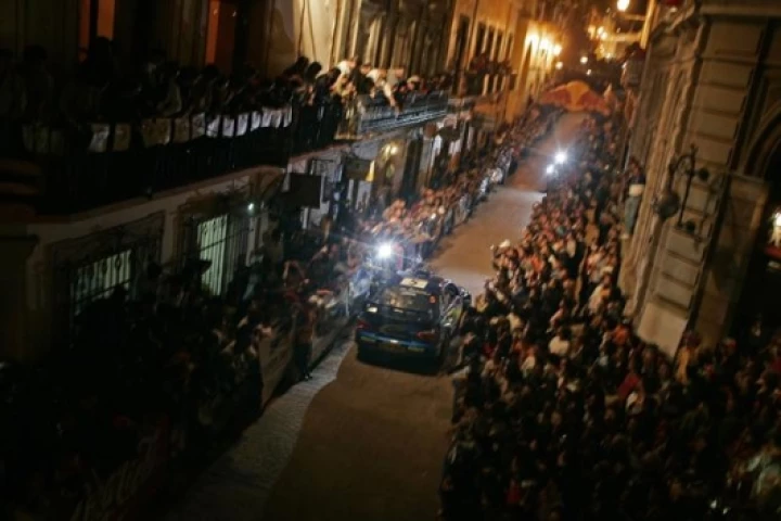 Subaru's Petter Solberg parades through town on the night preceding the rally start