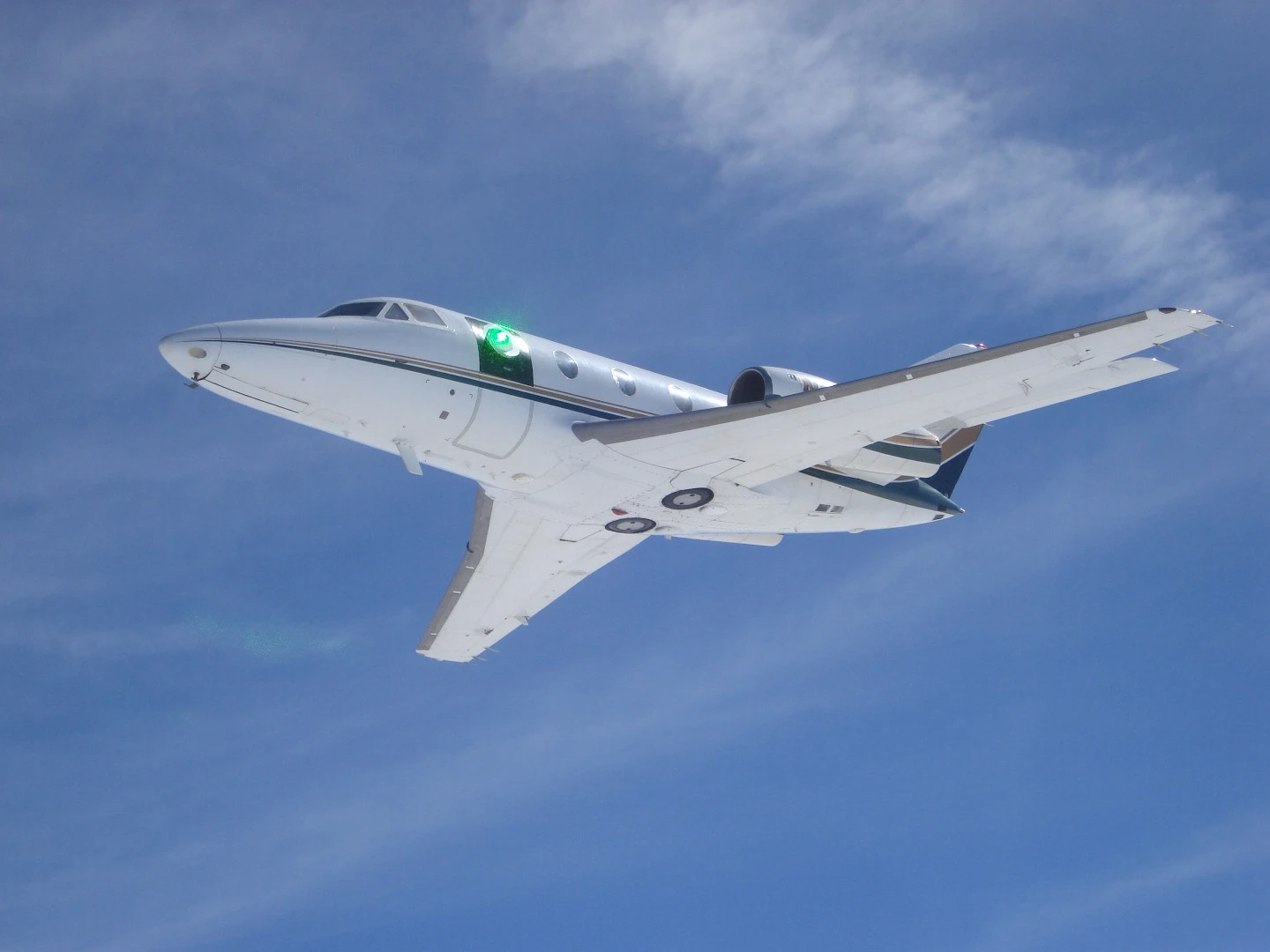A green low-power laser beam passes through the turret on a research aircraft