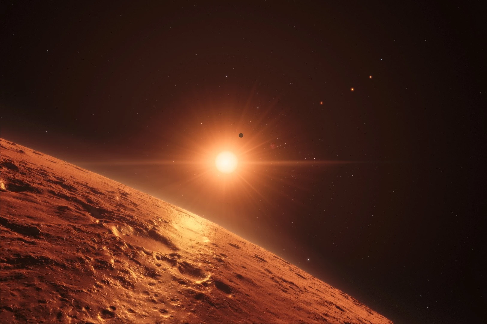 This artist’s impression shows the view just above the surface of one of the middle planets in the TRAPPIST-1 system, with the glare of the host star illuminating the rocky surface