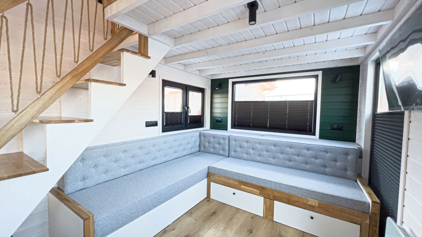 The Mobi Individual Baobab's living room includes a large L-shaped sofa bed with integrated storage