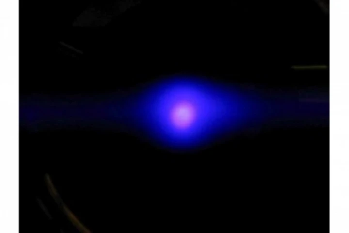 About 1 million ytterbium atoms illuminated by a blue laser in an experimental atomic clock that holds the atoms in a lattice made of intersecting laser beams (Photo: Barber, NIST)