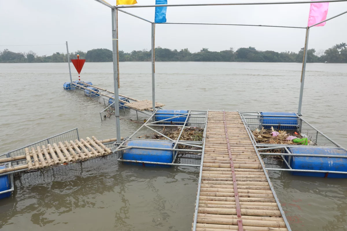 A locally designed, inexpensive trash trap has been installed along Vietnam's Song Hong River to remove floating debris such as plastic waste